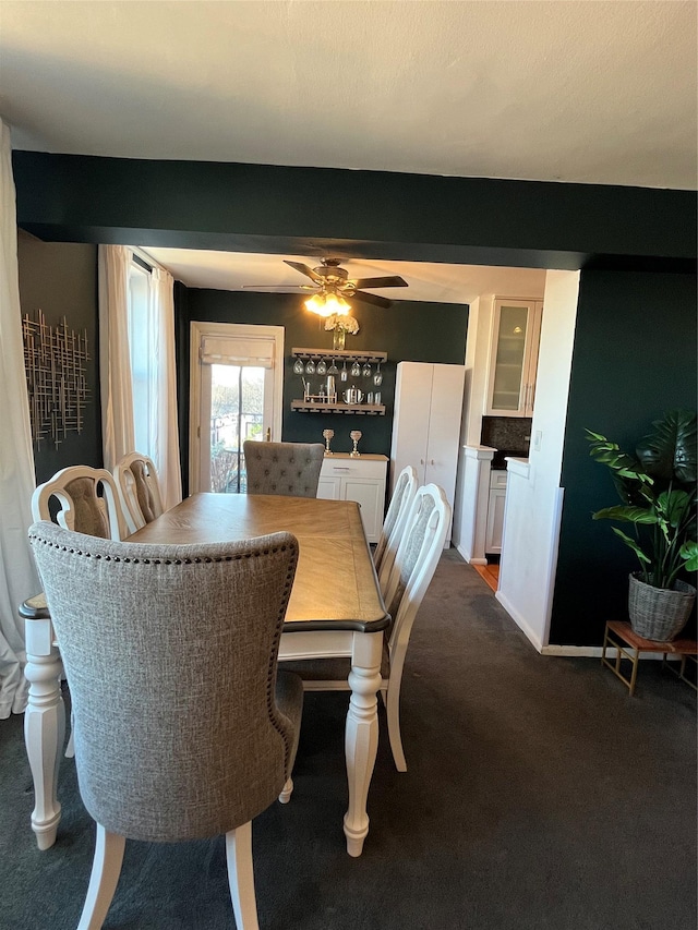 carpeted dining space with ceiling fan