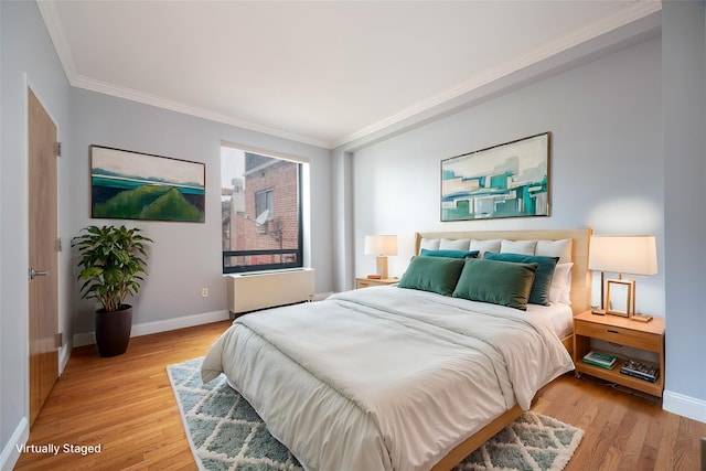 bedroom featuring ornamental molding and light wood-type flooring