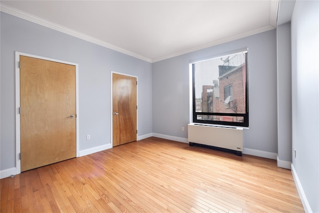 unfurnished bedroom featuring radiator heating unit, ornamental molding, and light hardwood / wood-style floors