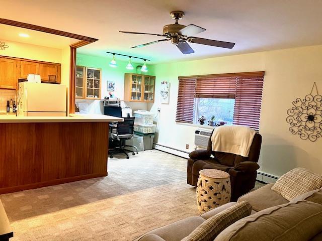 living room with ceiling fan, a baseboard radiator, and light colored carpet