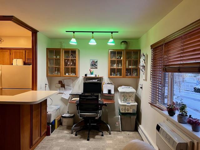 home office with a wall mounted air conditioner, a baseboard radiator, and rail lighting