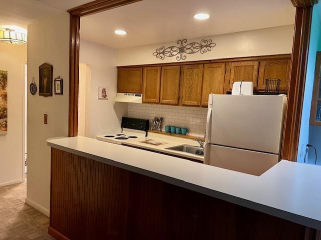 kitchen with sink, white appliances, and tasteful backsplash