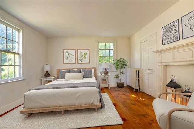 bedroom featuring hardwood / wood-style floors and radiator heating unit