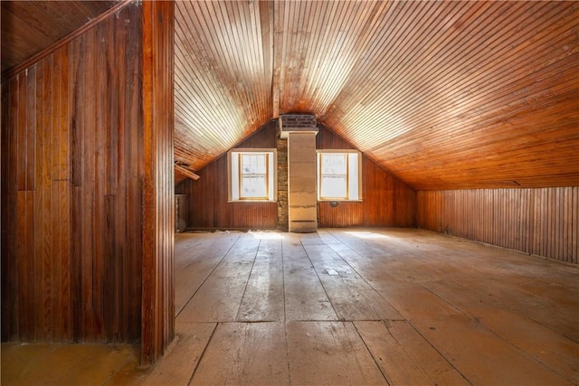 additional living space with lofted ceiling and wood walls