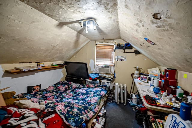 bedroom featuring radiator, a textured ceiling, cooling unit, and vaulted ceiling