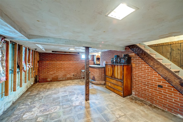 basement with brick wall and bar area