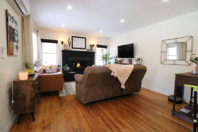 living room with hardwood / wood-style floors and a wall mounted air conditioner