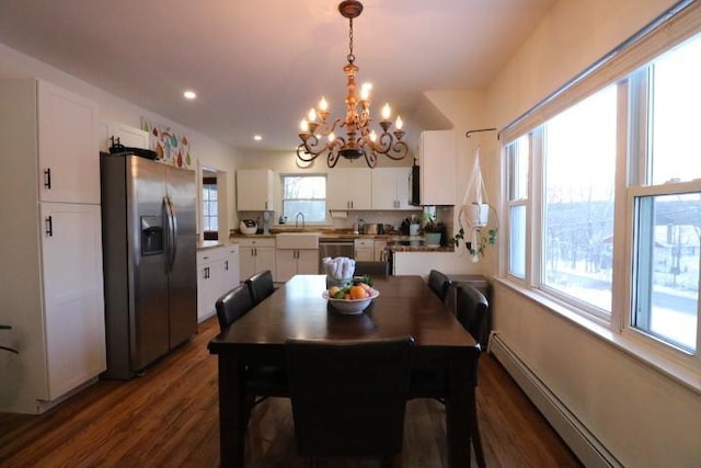 dining room featuring a notable chandelier, baseboard heating, dark hardwood / wood-style floors, and sink