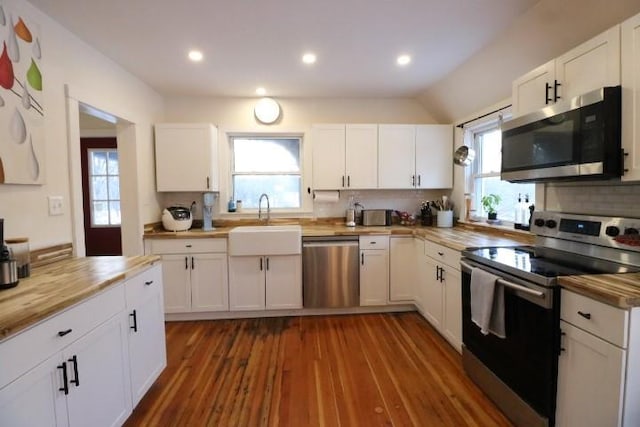 kitchen featuring white cabinetry, stainless steel appliances, decorative backsplash, dark hardwood / wood-style floors, and sink