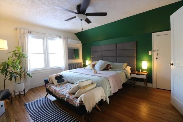 bedroom featuring ceiling fan, dark hardwood / wood-style flooring, and a textured ceiling