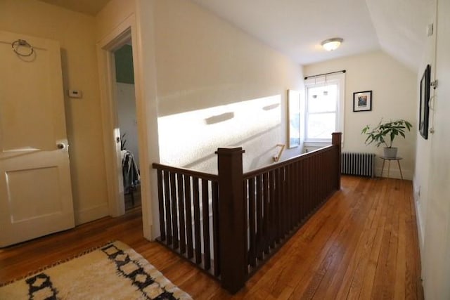 hallway with radiator, lofted ceiling, and wood-type flooring