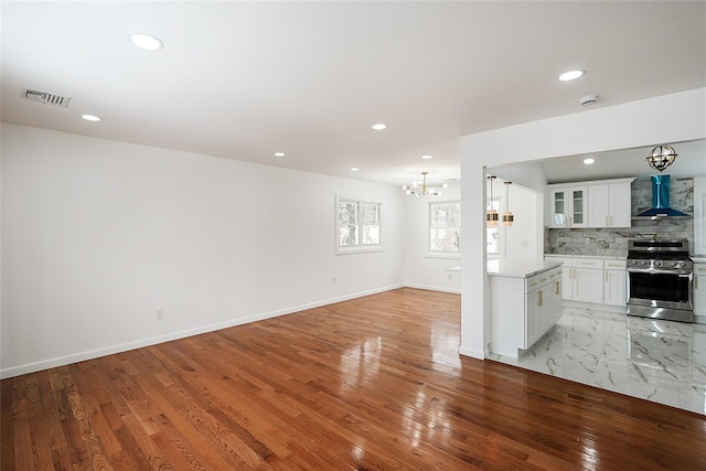 unfurnished living room with a chandelier and light hardwood / wood-style flooring