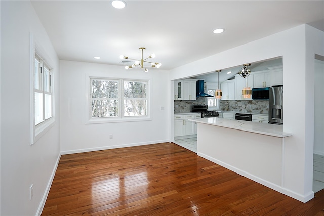 kitchen featuring decorative light fixtures, white cabinets, decorative backsplash, and stainless steel appliances