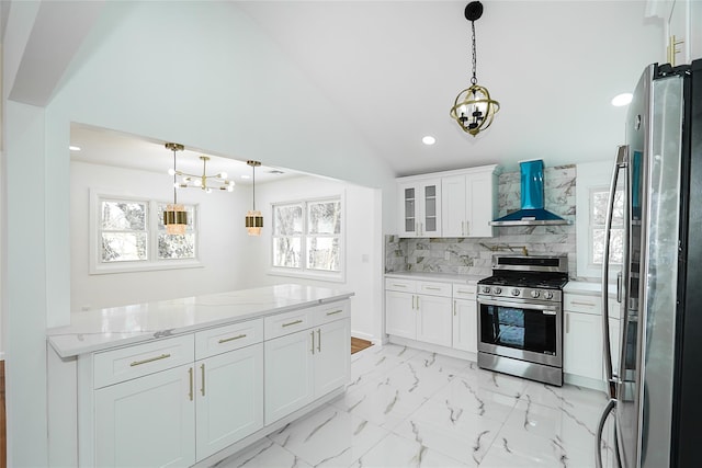 kitchen with lofted ceiling, backsplash, wall chimney range hood, appliances with stainless steel finishes, and white cabinets