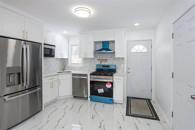 kitchen with sink, wall chimney range hood, stainless steel appliances, and white cabinetry