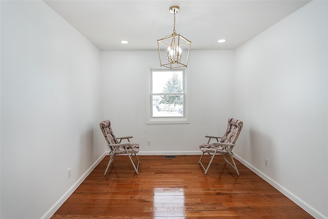 unfurnished room with wood-type flooring and an inviting chandelier