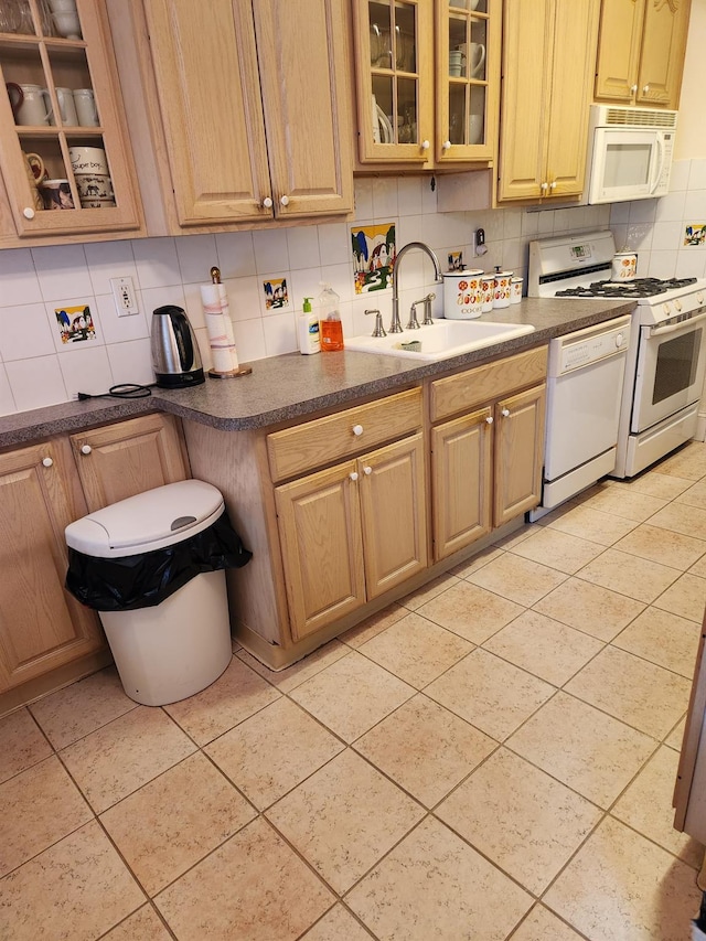 kitchen featuring tasteful backsplash, light tile patterned floors, sink, and white appliances