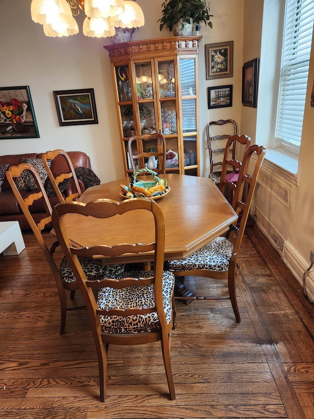 dining room featuring dark parquet flooring and a chandelier