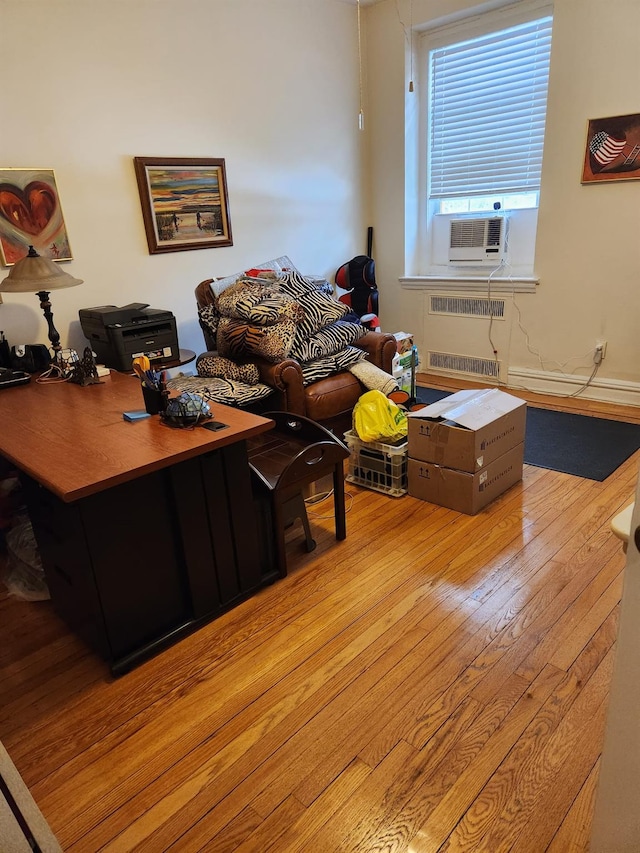 living room featuring cooling unit, radiator heating unit, and light hardwood / wood-style floors