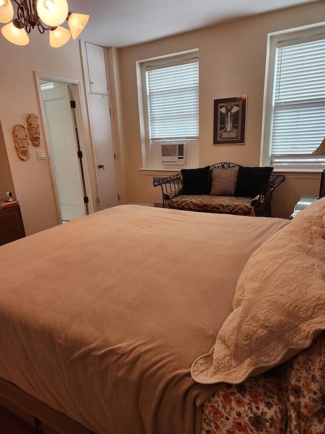 bedroom with cooling unit and a notable chandelier