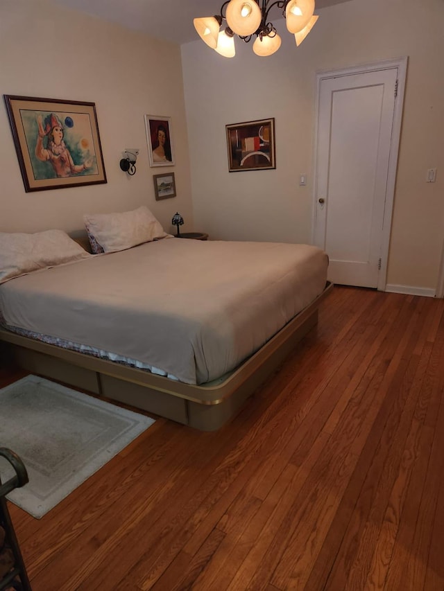 bedroom featuring a chandelier and hardwood / wood-style flooring