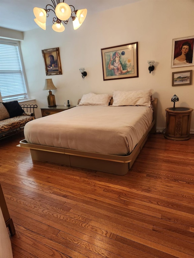 bedroom with dark hardwood / wood-style floors and a notable chandelier