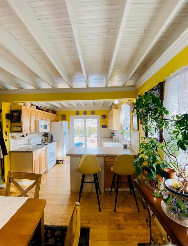 kitchen with a kitchen breakfast bar, white appliances, kitchen peninsula, and light wood-type flooring