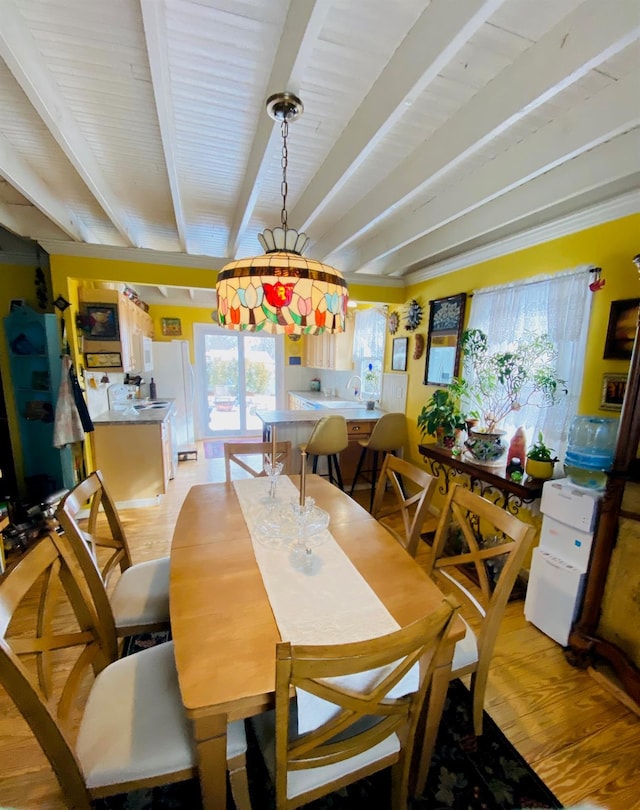 dining space featuring light hardwood / wood-style floors and beam ceiling