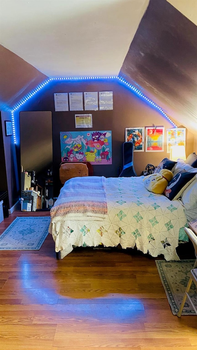 bedroom with wood-type flooring and vaulted ceiling