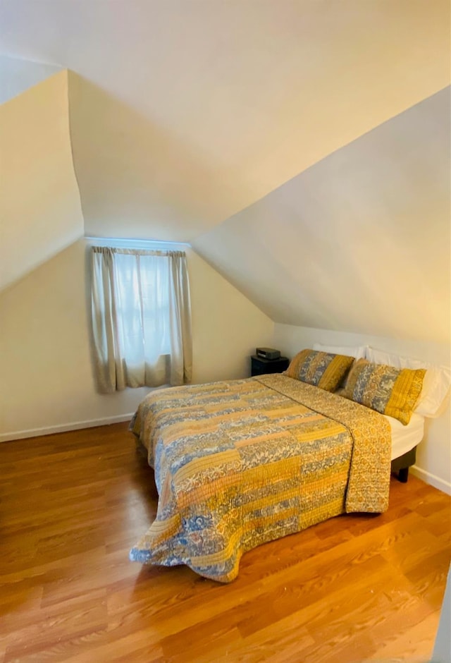 bedroom featuring wood-type flooring and lofted ceiling