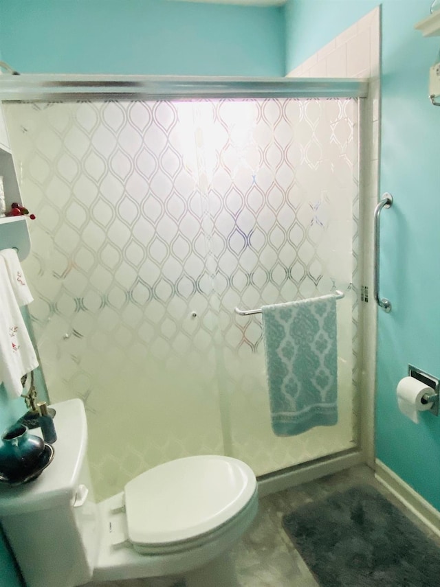 bathroom featuring toilet and an enclosed shower