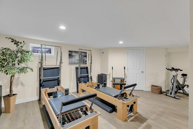 exercise room with recessed lighting, light wood-style flooring, and baseboards