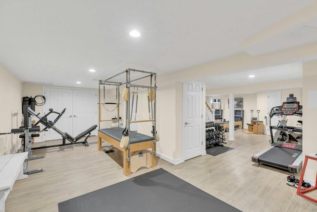 exercise area featuring baseboards, wood finished floors, and recessed lighting