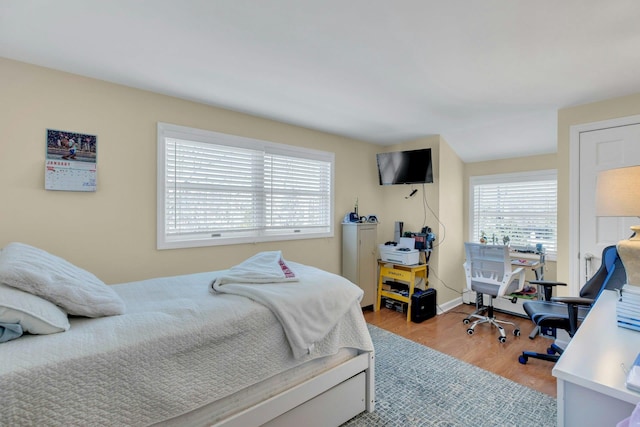 bedroom with wood finished floors and baseboards