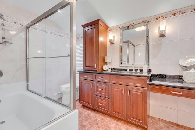 bathroom with vanity, a tile shower, tile walls, and tile patterned floors