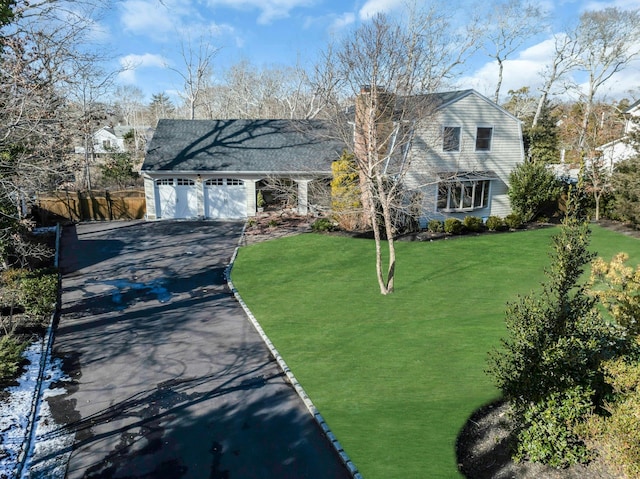 view of front of home with an attached garage, driveway, a front yard, and a gambrel roof