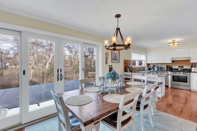11 Harbor Rd, Hampton Bays, NY 11946 - dining area featuring a chandelier, ornamental molding, light wood-style floors, and french doors