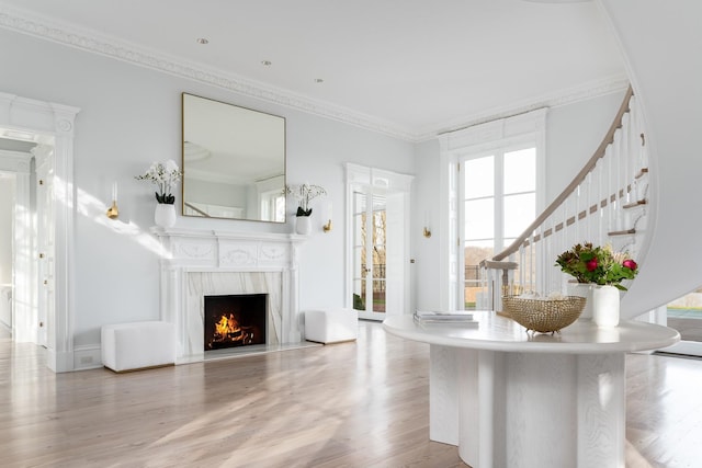 unfurnished living room with hardwood / wood-style flooring, crown molding, and a fireplace