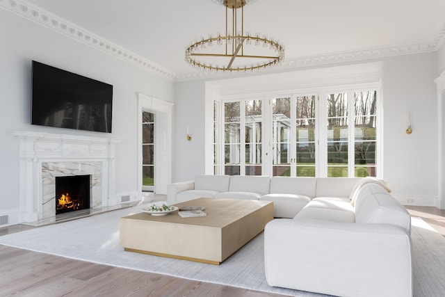 living room featuring ornamental molding, a fireplace, and light hardwood / wood-style floors