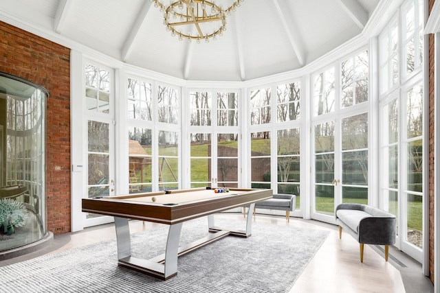 sunroom / solarium featuring beam ceiling, pool table, and a chandelier