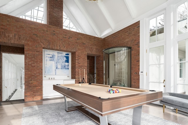 playroom featuring pool table, beam ceiling, high vaulted ceiling, and brick wall