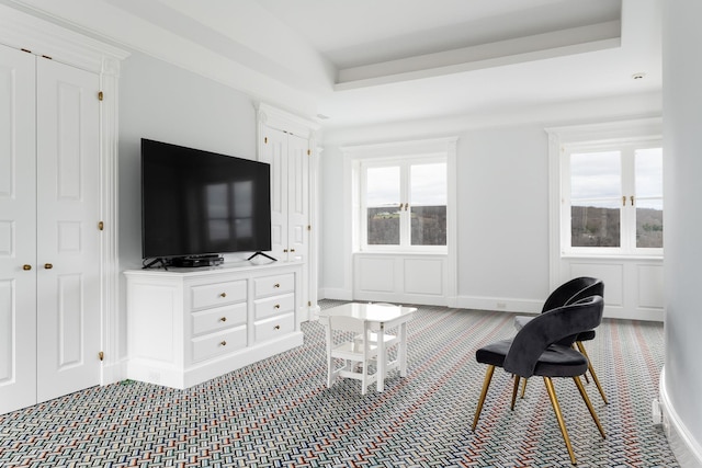 living room with carpet floors, a wealth of natural light, and a raised ceiling