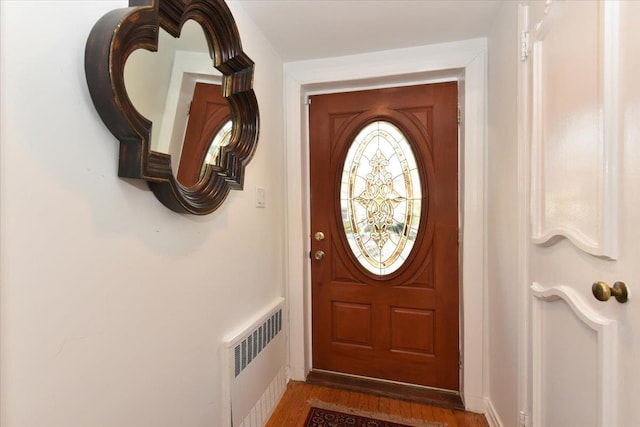 doorway featuring wood-type flooring and radiator heating unit