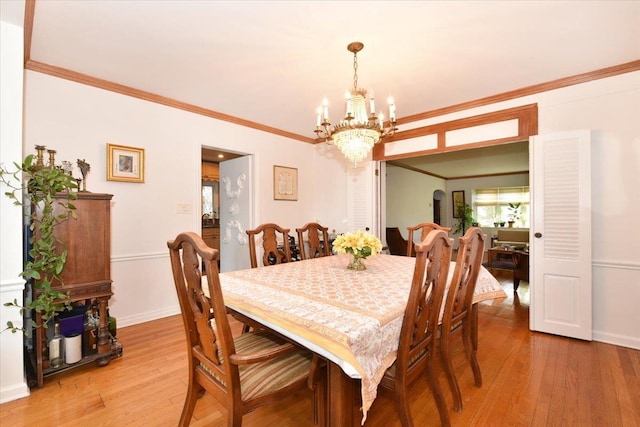 dining area with a chandelier, ornamental molding, and hardwood / wood-style flooring