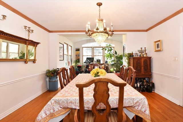 dining room featuring light wood-type flooring, a chandelier, and ornamental molding