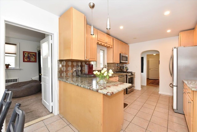 kitchen with tasteful backsplash, decorative light fixtures, kitchen peninsula, appliances with stainless steel finishes, and light brown cabinets