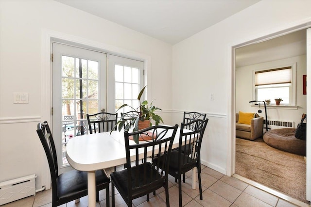 dining room with light tile patterned floors, baseboard heating, french doors, and radiator heating unit