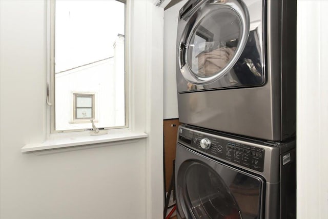 washroom with stacked washing maching and dryer