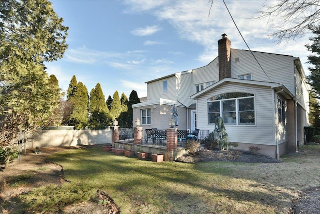 rear view of property featuring a lawn