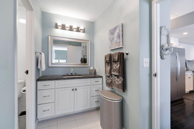 bathroom with vanity, a textured ceiling, and toilet